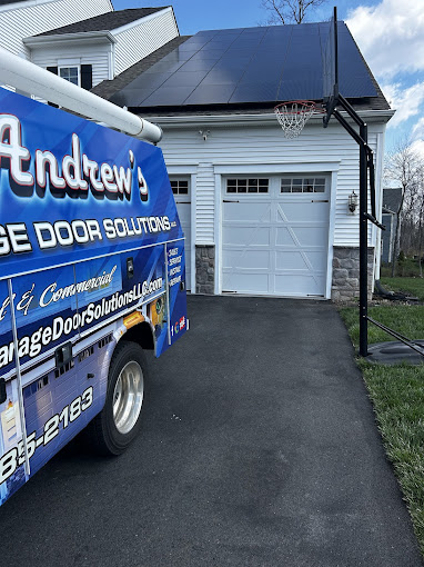 Blue service van parked next to garage with solar panels