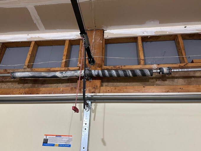 Garage door spring and metal track mounted on wooden framing